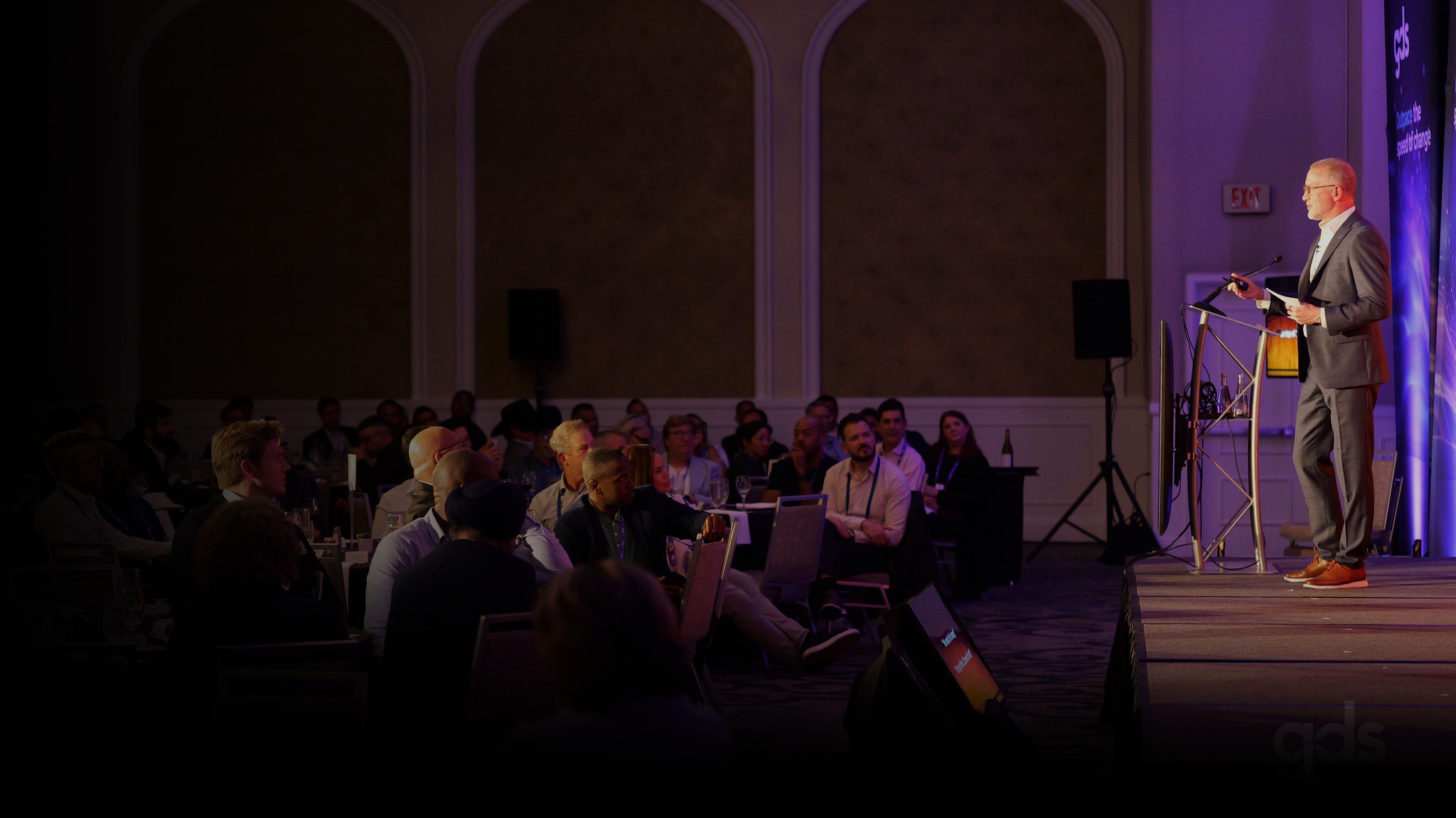 A GDS speaker addressing executives at an in-person Summit